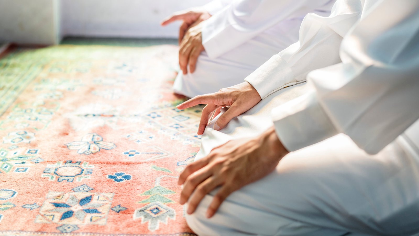 Muslim men praying in Tashahhud posture